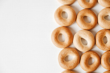 Drying or mini round bagels on a white wooden background. Top view. Copy, empty space for text