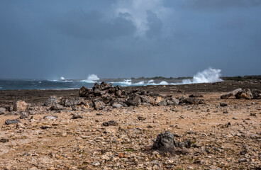The rugged coast with high waves and dark clouds at Boka Onima in the North-East of Bonaire.