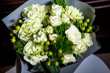 top view on pretty handmade bouquet of big white roses and fresh greenery