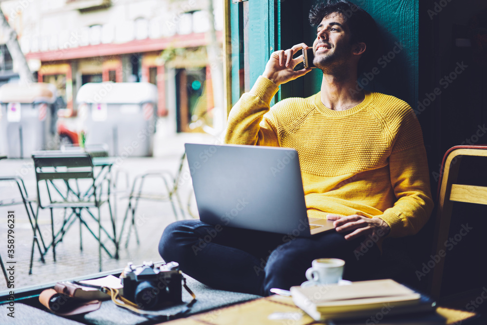 Poster handsome male owner of marketing company resting while having mobile conversation with friend postpo