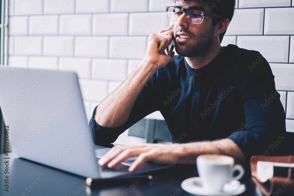 Poster cropped image of pensive graphic designer in optical eyeglasses checking accounting reports while ta