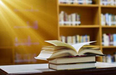 Open Book on wood table and blurred bookshelf in the library, education background, back to school concept.