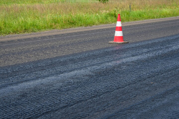 Traffic cones on the new asphalt. Road repair. Danger warning. Copy space.