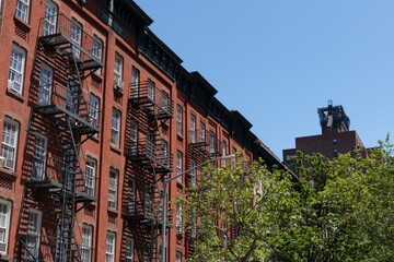 Row of Colorful Old Buildings with Fire Escapes on the Upper East Side of New York City with Green...