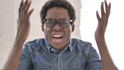 Angry African Man Yelling while Working in Office