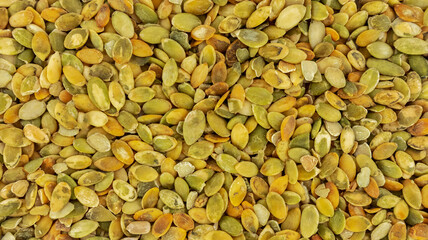 food background in the form of peeled pumpkin seeds