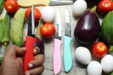 Hand holding knife and diet and health background with eggs and vegetables with selective focus.