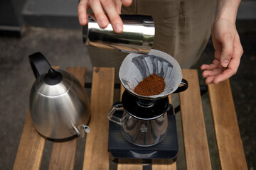 Brewing pour-over coffee. Hot coffee pouring through paper filter on dark wooden table top view