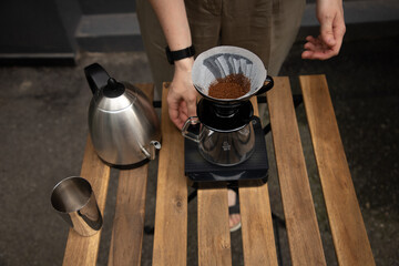 Brewing pour-over coffee. Hot coffee pouring through paper filter on dark wooden table top view