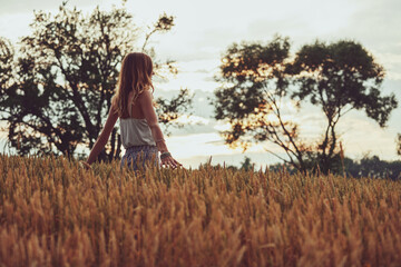 Young woman enjoying in a wheat field.