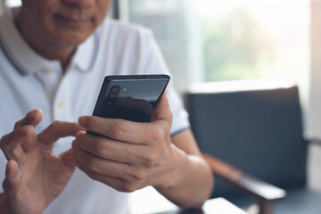 Asian casual man using mobile smart phone surfing the internet 