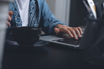 Woman hand typing on laptop computer surfing internet overtime working at night at home 