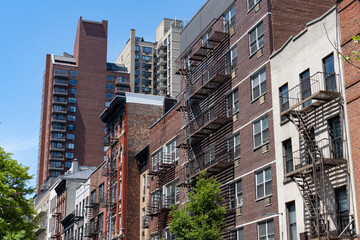 Row of Colorful Old Buildings with Fire Escapes on the Upper East Side of New York City with Green...