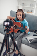 Fototapeta na wymiar Child guitarist making video lessons and tutorials for internet vlog website classes.