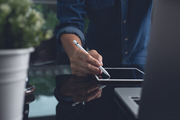 Man graphic designer working on digital tablet and laptop computer at home office