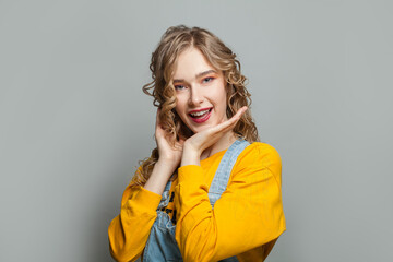 Young woman smiling on gray background