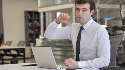 Thumbs Down by Young Businessman Looking at Camera