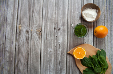 Natural home skin care. Ingredients of a face mask. Water decoction of plantain (Plantago major), orange and starch on a wooden background. Top view. Free space.