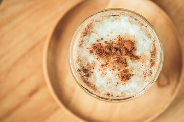 Iced coffee with milk froth on top with cinnamon powder