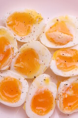 soft-boiled sunny side up halves of chicken eggs on the white plate bright orange background. close up shot. minimalism concept