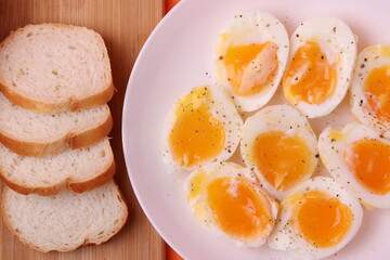 soft-boiled sunny side up halves of chicken eggs on the white plate bright orange background. close up shot. minimalism concept