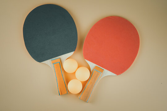 Black And Red Ping Pong Rackets And Three Orange Balls