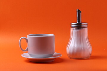 tea cup and a sugar pot bottle on orange