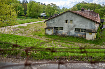 Old rural house with metal fence around it's garden