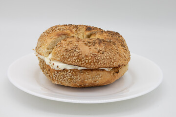 Toasted Sesame Seed Bagel with Cream Cheese on a White Plate