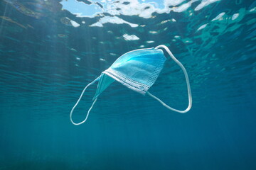 Disposable surgical face mask underwater, plastic waste in the ocean since coronavirus COVID-19...