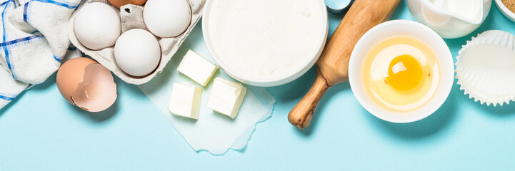 Baking ingredients at blue table top view.