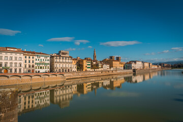 Fototapeta premium FLORENCE, TUSCANY / ITALY - DECEMBER 27 2019: Buildings reflecion in Arno river water in Florence
