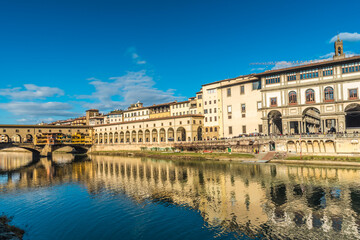 Fototapeta na wymiar FLORENCE, TUSCANY / ITALY - DECEMBER 27 2019: Buildings reflecion in Arno river water in Florence