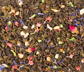 Tie Guan Yin tea with rose buds, candied fruit, cornflower petals. Organic tea background. Top view. Close up.