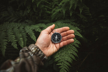 Explorer people holding a compass and searching the right directions in the jungle.Survival travel,lifestyle concept.	