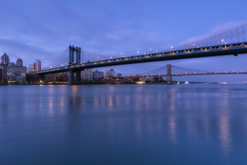 Fototapeta na wymiar View on Dumbo location from East River with long exposure at dawn