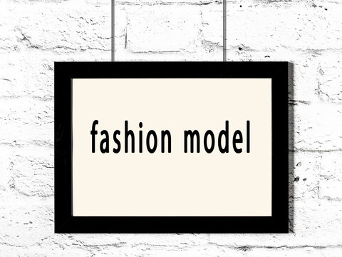 Black frame hanging on white brick wall with inscription fashion model