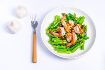 Stirred fried asparagus with shrimp served on white plate isolated on white background. famous thai food in thailand. popular food in Asia.