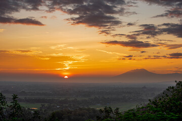 Fototapeta na wymiar First light of beautiful sunrise in Java Island with Lawu Volcano and foggy land