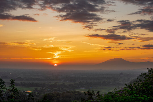 First light of beautiful sunrise in Java Island with Lawu Volcano and foggy land