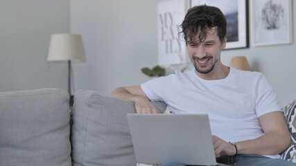 Online Video Chat on Laptop by Relaxing Young Man