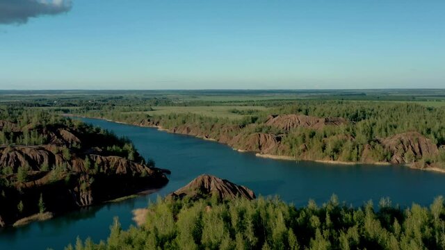 Romantsevo hills and lakes in Tula oblast drone aerial shot drone aerial zoom in. Fly over tulskaya oblast romantsevskie hills, konduki shot under cloudy blue sky
