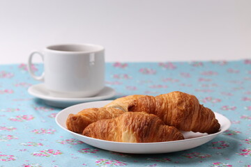 delicious french croissants and a white ceramic coffee cup 