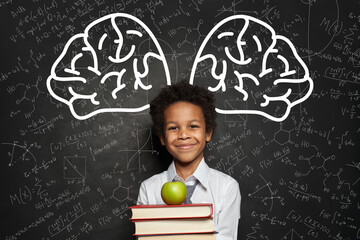 Happy smart kid student on blackboard background, brainstorming concept