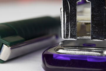 macro photo of blue ballpoint pen and stapler on the white paper page as background