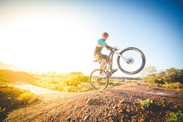 Obraz premium Wide angle view of a mountain biker speeding downhill on a mountain bike track.
