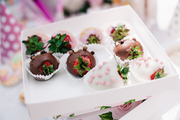 Large strawberries in chocolate with decorations in gift packaging