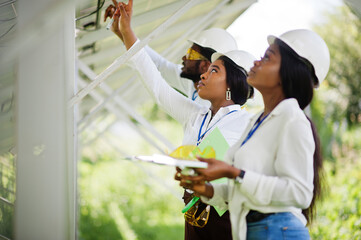 African american technician checks the maintenance of the solar panels. Group of three black...