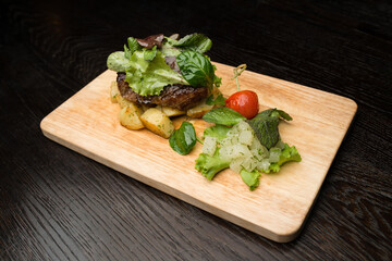 grilled beef with vegetables on wooden board