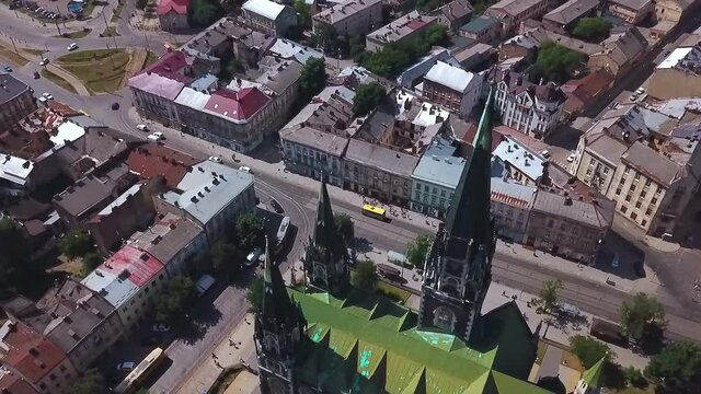 Old catholic church, street traffic life and buildings. Drone aerial video of Saint Olga and Elizaveta Church in central part of old city of Lviv, Ukraine